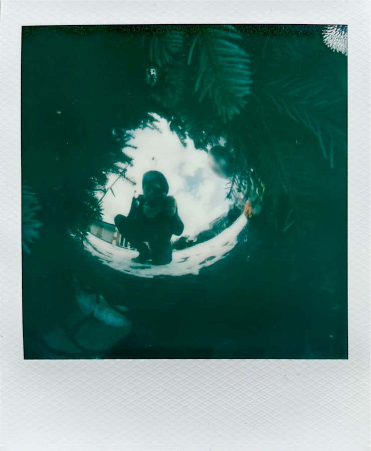 A reflection of me in a large christmas tree ball. Twigs surrounding it.