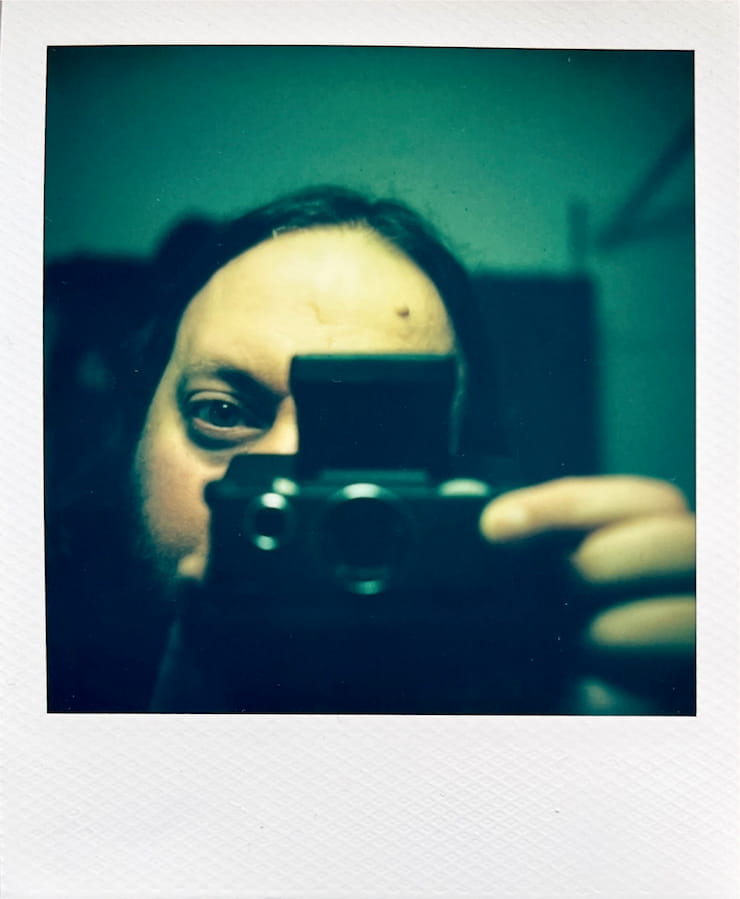 Selfprotrait of me in the mirror with my SX-70 camera, only one
      eye peaking from behing the camera, the other half of my face covered by
      the camera.