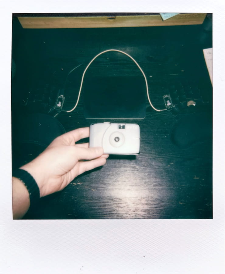 Holding my tiny blue plastic RETO Ultra Wide and Slim camera at
      arms length.