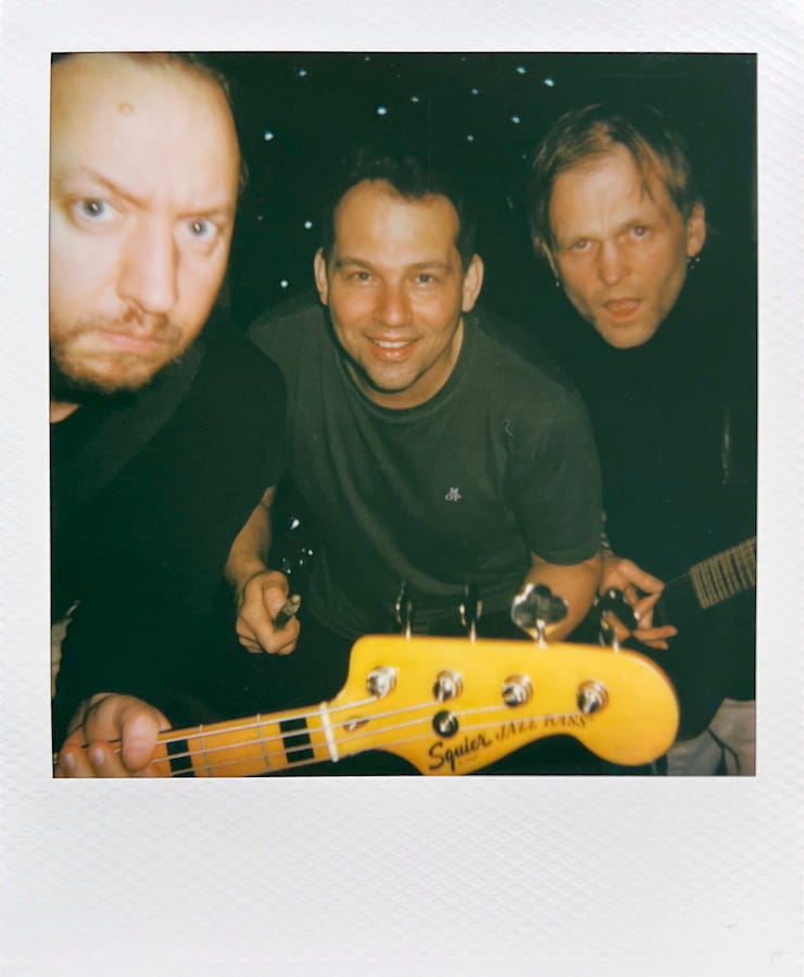 The three men of the band Forkalyst being silly, looking into
      the camera.