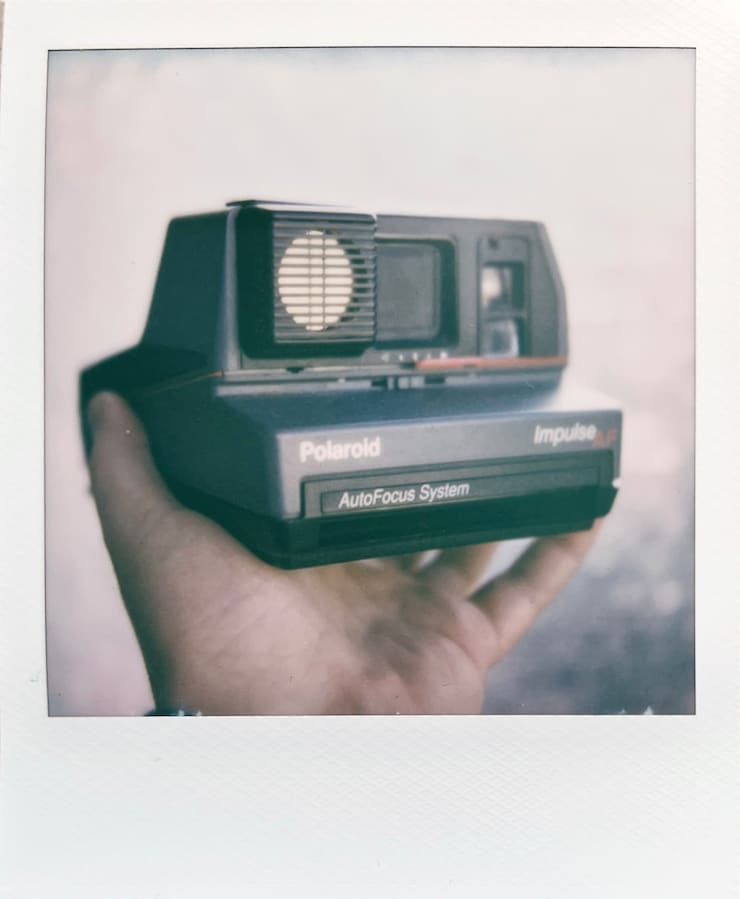 A close-up photo of the Polaroid Impulse AF camera in my
      hand.
