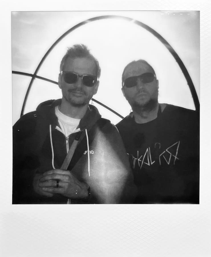 Two men with sunglasses looking into the camera. The sculpture
      of Halde Hoheward.