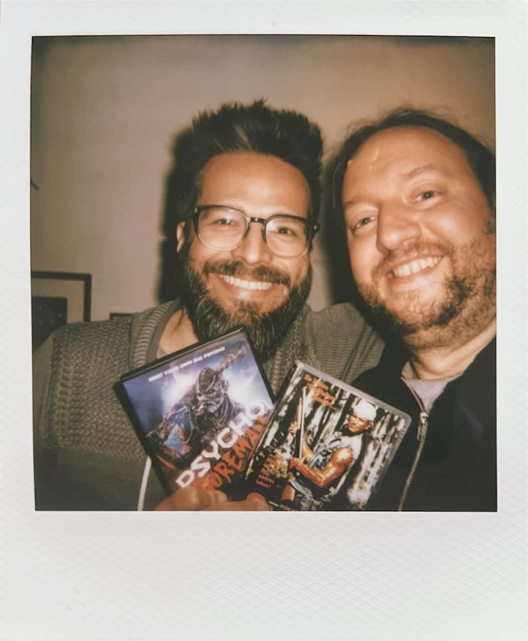 Me and a friend smiling into the camera, holding DVDs of
      
