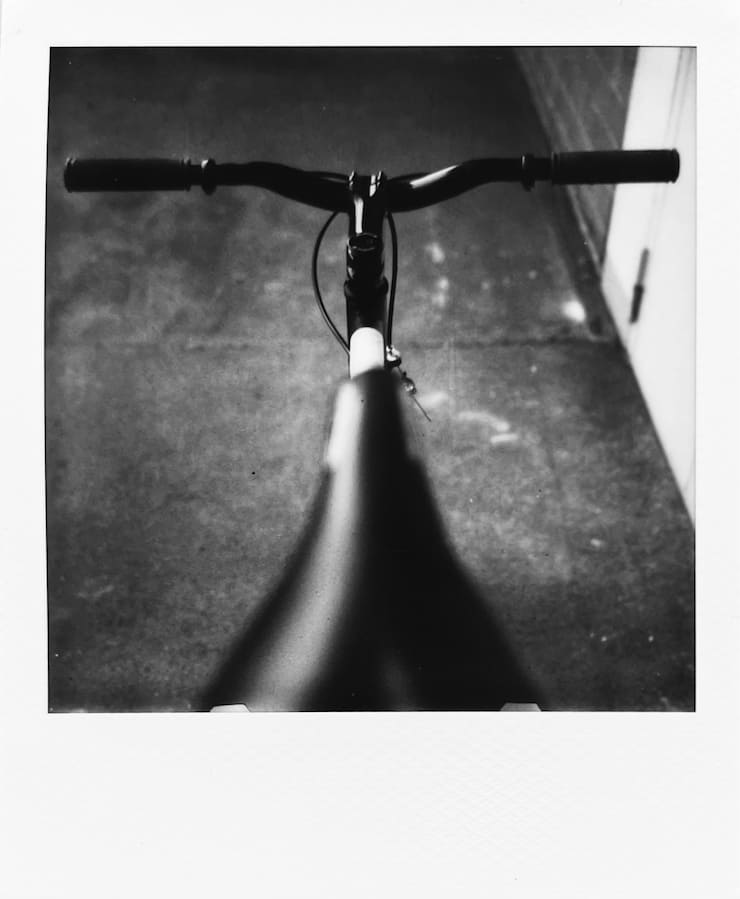 Parts of a bike. Mostly focusing on the handlebars, photographed
      from behind the bike. The saddle in the foreground.