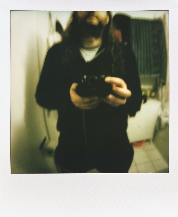 Me from nose to knees in a bathroom mirror with some towels and a cupboard.