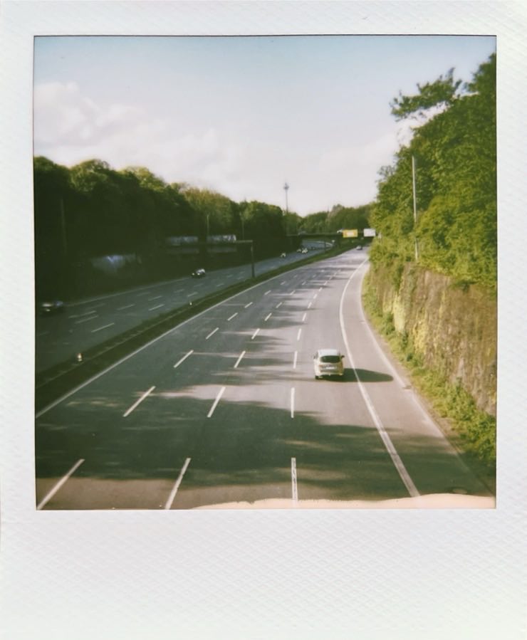 A multilane highway surrounded by walls and trees.
