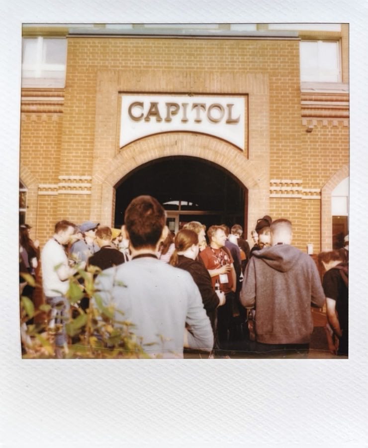 The Capitol Theater in Düsseldorf with a large group of people standing in front of it.
