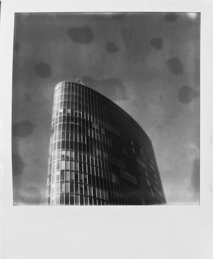 A b&w photo of highrise building in front of a cloudless sky.
