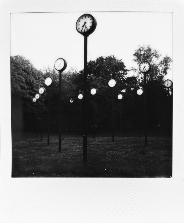 The Zeitfeld in Düsseldorf. Multiple clocks on a lamppost in a park.