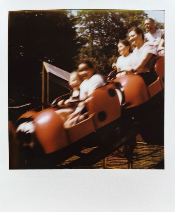 Blurry picture of two little girls on a red rollercoaster.