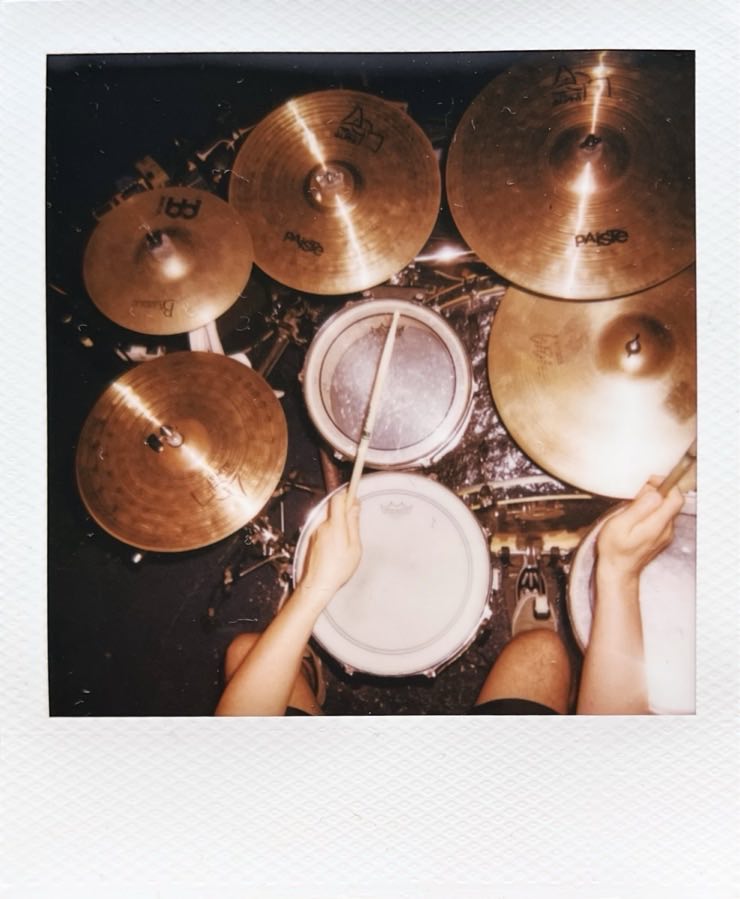 A drum set from above. A drumming drummer partially seen.