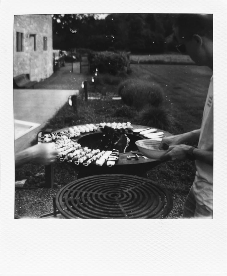 A round bbq with vegetables on it.