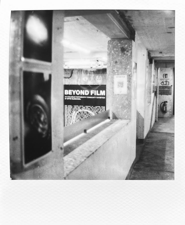Shooting through a gap in an exhibition space where the poster in the background says Beyond Film