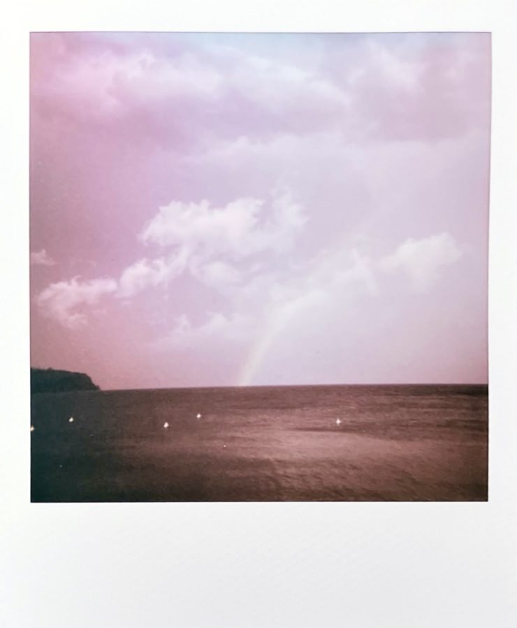 Lake Garda with heavy clouds and half a rainbow.